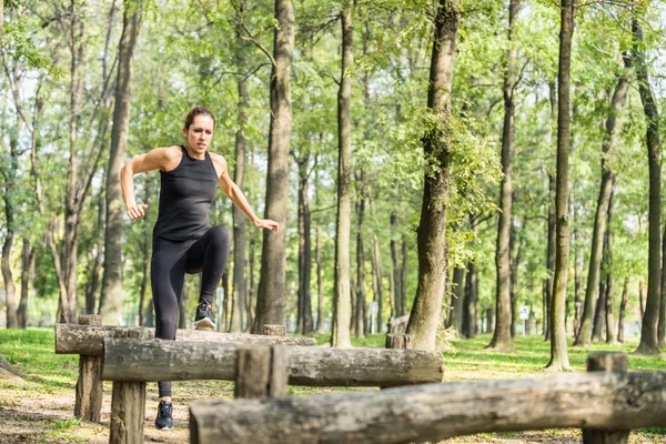 Женщина-спортсмен прыгает по фитнес-тропе — стоковое фото