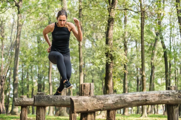 Vrouwelijke atleet op houten horden — Stockfoto