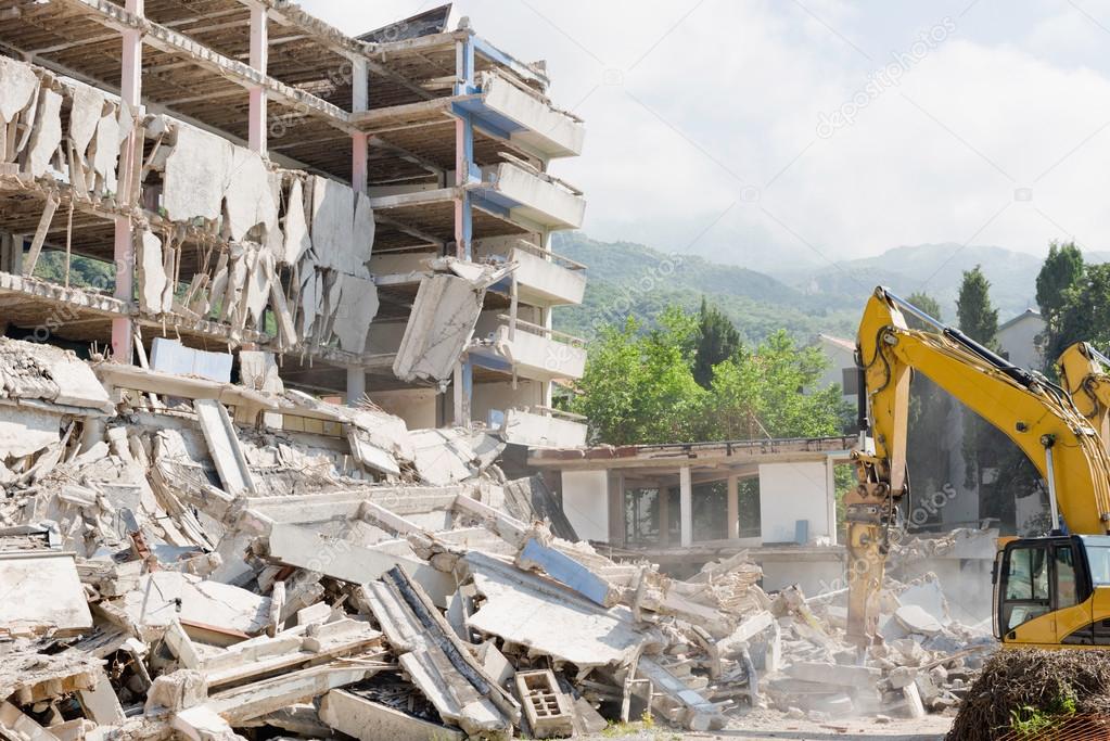 Construction machines demolishing building