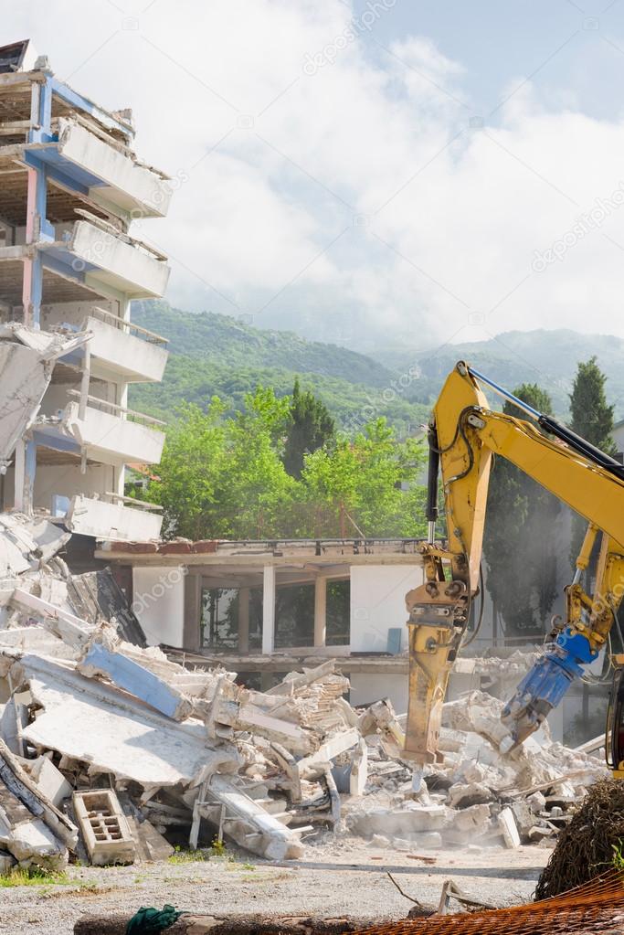 Construction machines demolishing building