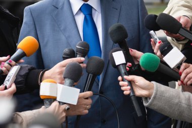 politikacı çevreleyen gazeteciler