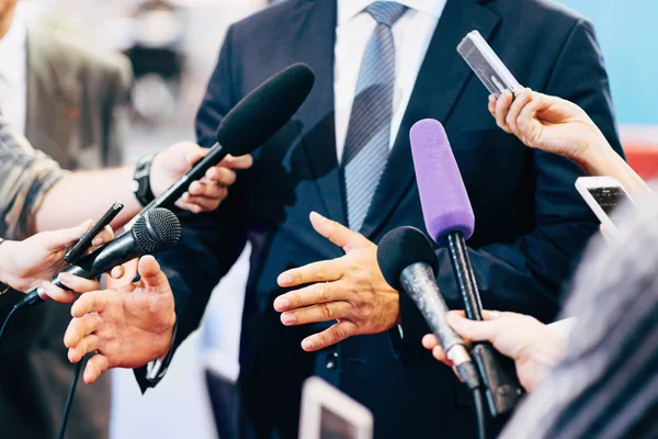 Microphones médiatiques entourant l'homme politique — Photo