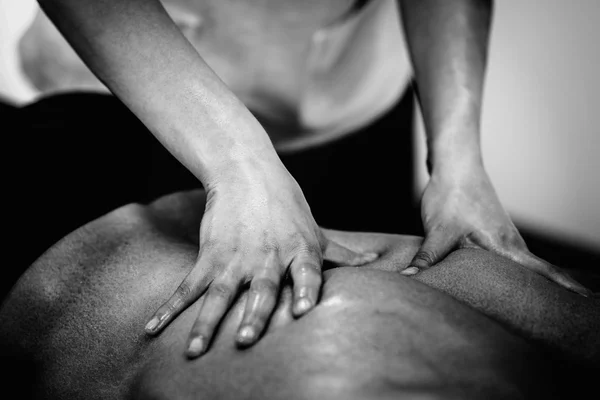 Physical therapist doing massage of lower back — Stock Photo, Image