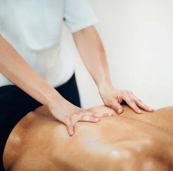 Physical therapist doing massage of athlete back — Stock Photo, Image