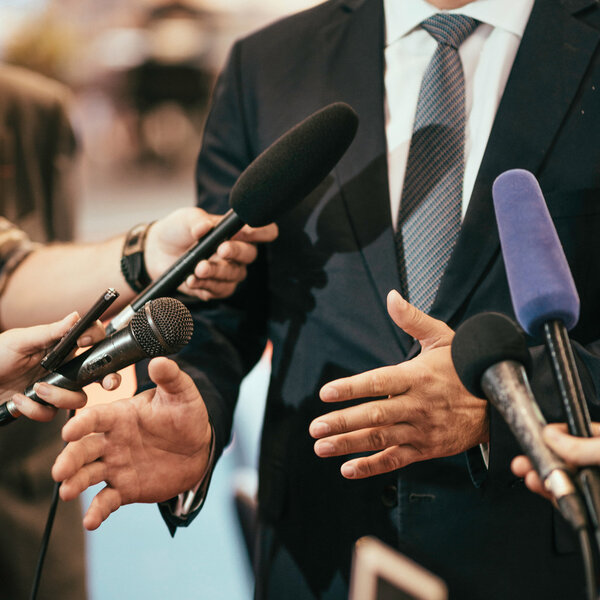 Media microphones surrounding politician