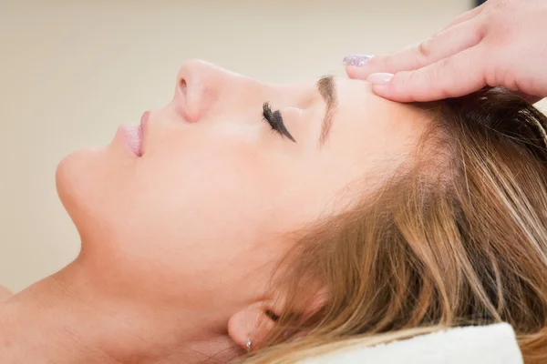 Giovane donna godendo di massaggio facciale — Foto Stock