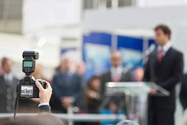 Fotógrafo con cámara en conferencia de prensa — Foto de Stock