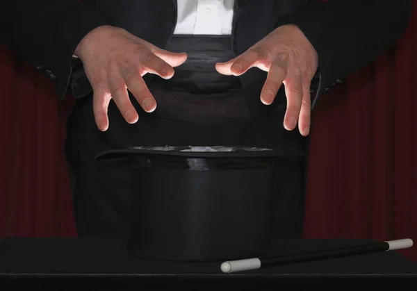 Magician hands above top hat — Stock Photo, Image