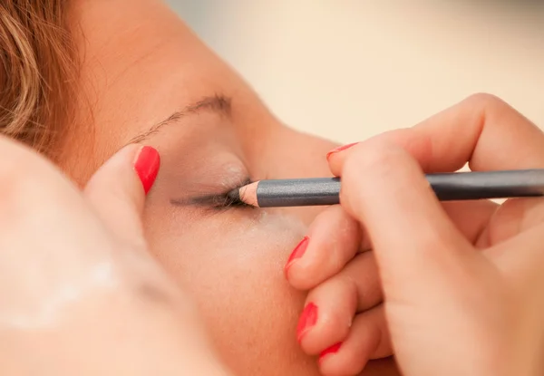 Maquillaje artista aplicando delineador de ojos — Foto de Stock