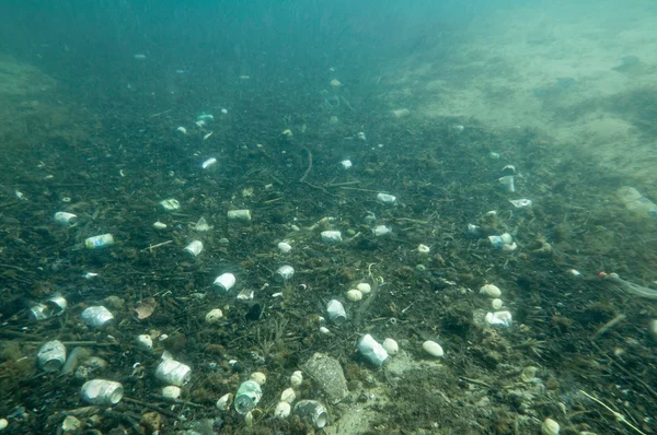 Plåtburkar och plast skräp i havet — Stockfoto