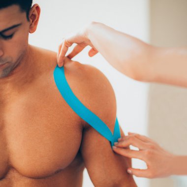 therapist placing kinesio tape on shoulder clipart