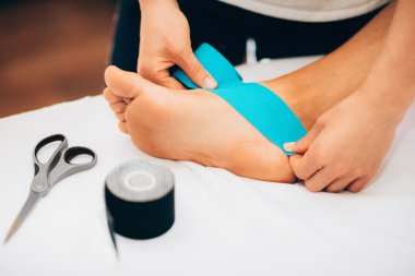 Physical therapist placing kinesio tape clipart