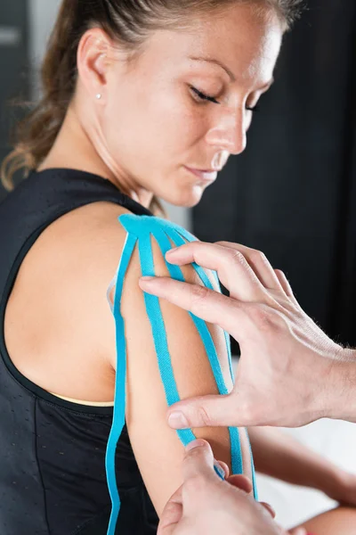 Therapeut legt Kinesiotape auf Schulter — Stockfoto