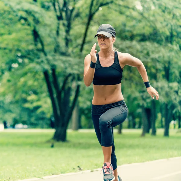 Giovane donna che corre nel parco — Foto Stock