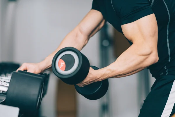 Muscular young man in gym — Stock Photo, Image