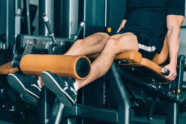 Hombre muscular haciendo ejercicio en el gimnasio — Foto de Stock