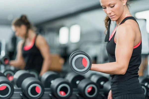 Mujer joven haciendo ejercicio en el gimnasio — Foto de Stock