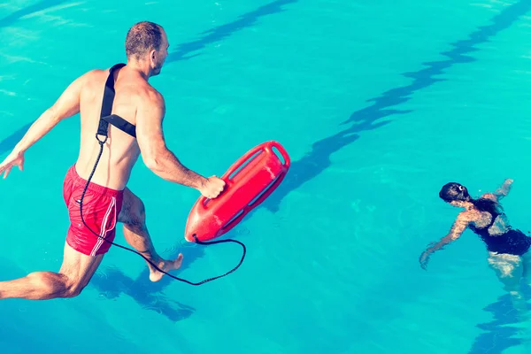 Lifeguard jumping towards victim — Stock Photo, Image