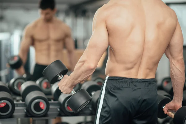 Man träna med vikter i gymmet — Stockfoto