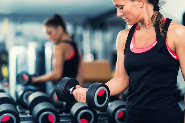 Spor salonunda egzersiz yapan genç bir kadın. — Stok fotoğraf