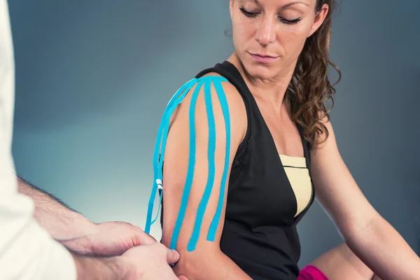 Terapeuta segítségével kinesio tape, a beteg — Stock Fotó