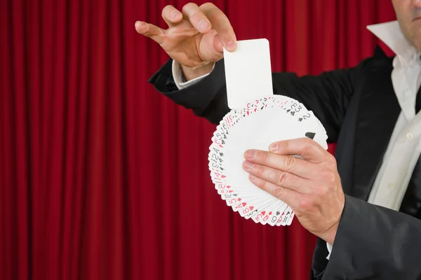 Magician pulling blank card out of deck — Stock Photo, Image