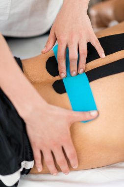 Physical therapist placing kinesio tape clipart