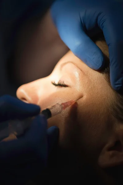 Dokter gezicht injectie geven vrouw — Stockfoto
