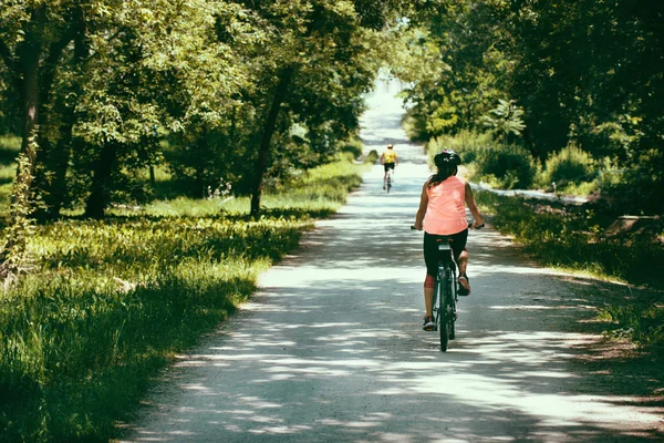 Женщина на велосипеде по дороге — стоковое фото
