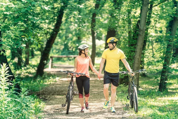 Couple in love  walking with bicycles — Stock Photo, Image