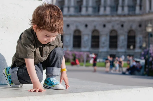 Menino brincando na praça da cidade — Fotografia de Stock