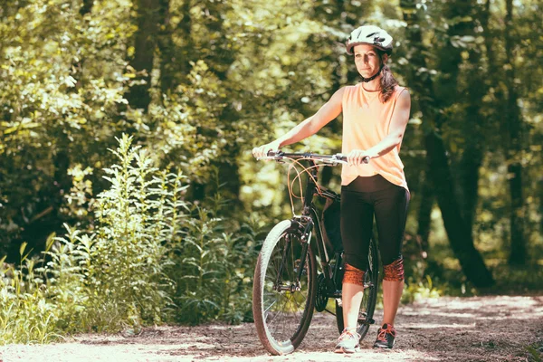 Vrouw met fiets in bos — Stockfoto