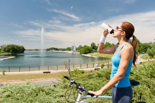 Mountainbike vrouw neemt water pauze — Stockfoto