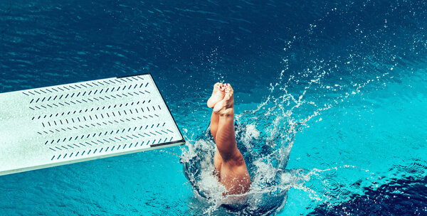 Female diver jumping from platform