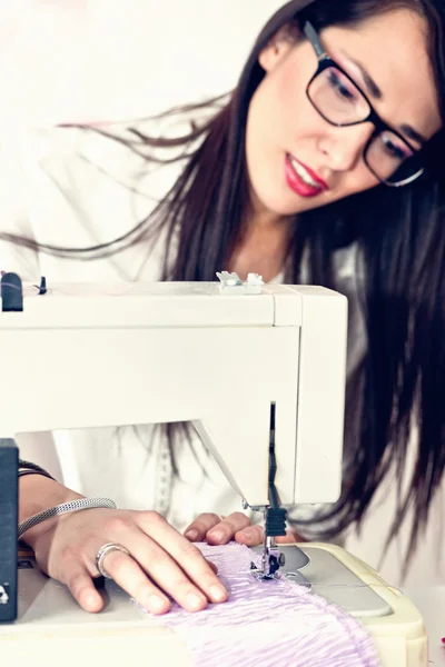재봉틀을 사용 하는 젊은 여자 — 스톡 사진