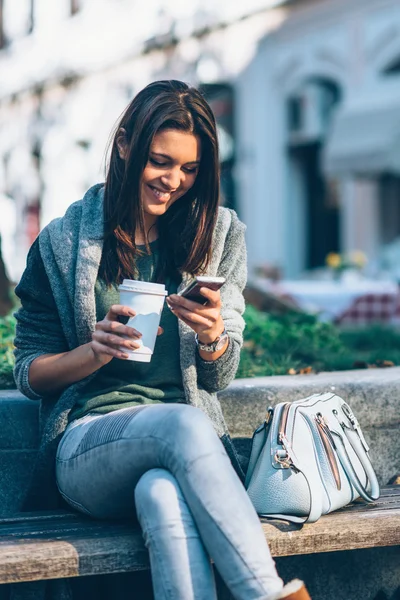 Hermosa chica con café y teléfono — Foto de Stock