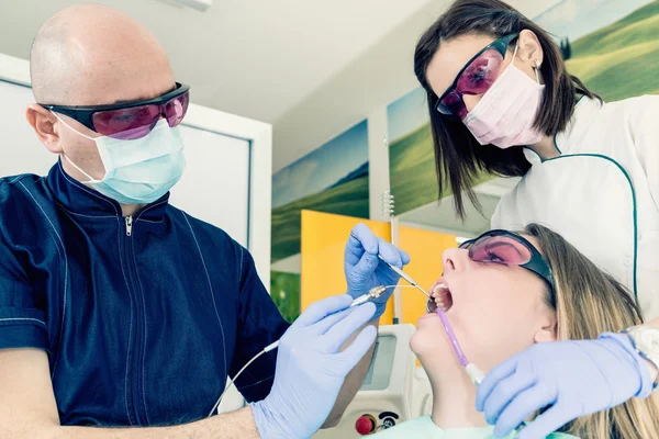 Dentiste effectuant une chirurgie laser mineure — Photo