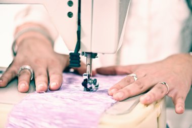 dikiş makinesi üzerinde çalışan tasarımcı