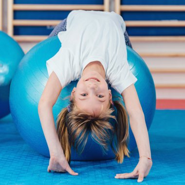 Küçük kız Fitness topu yere germe
