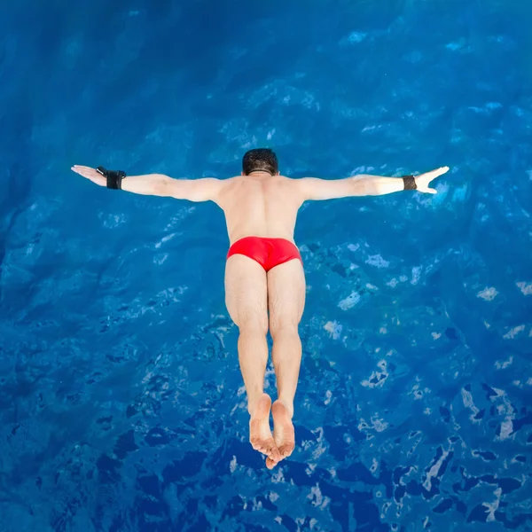 Diver flying towards water from platform — Stock Photo, Image