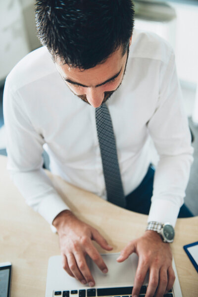 Офисный работник печатает на ноутбуке
