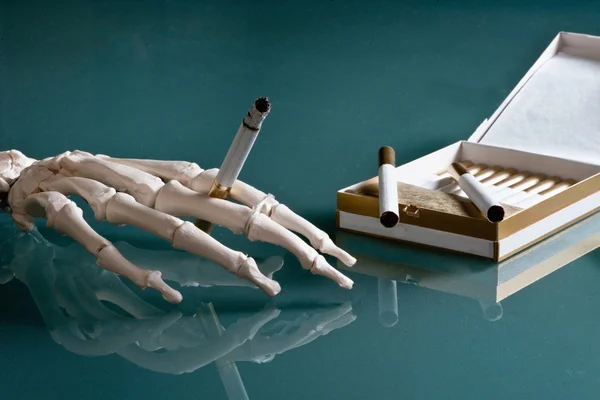 Skeleton hand with cigarette — Stock Photo, Image