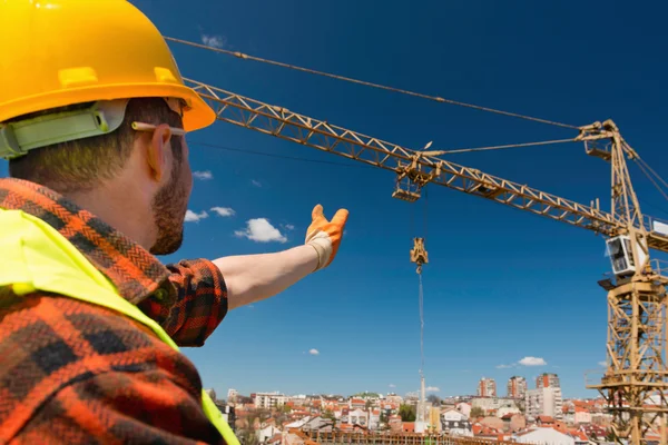 Byggnadsarbetare över crane — Stockfoto