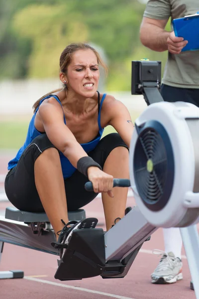 Mulher durante o treino da máquina de remo — Fotografia de Stock