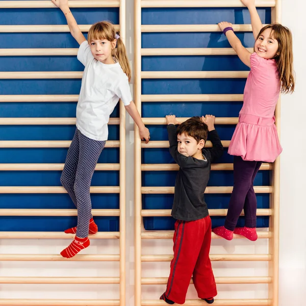 Children climbing on wall bars — Stock Photo, Image