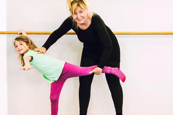 Инструктор, помогающий девушке на балете — стоковое фото