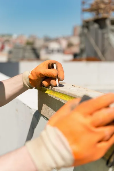建設労働者は、木製の梁を測定 — ストック写真