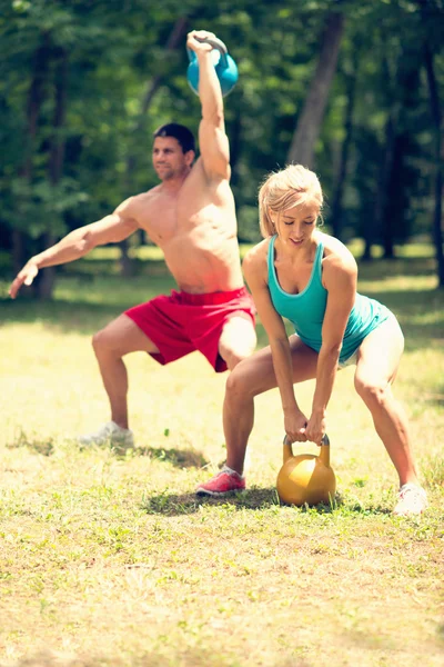 Couple fitness avec cloches à bouilloire — Photo