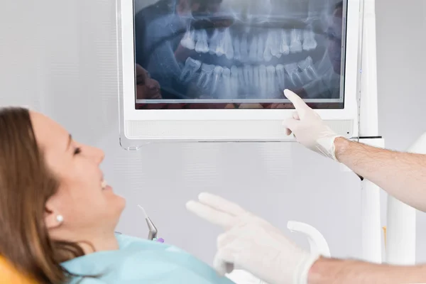 Dentista com radiografia e paciente do sexo feminino — Fotografia de Stock