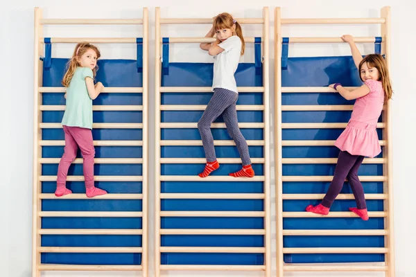 Küçük kızlar duvar çubukları üzerinde tırmanma — Stok fotoğraf